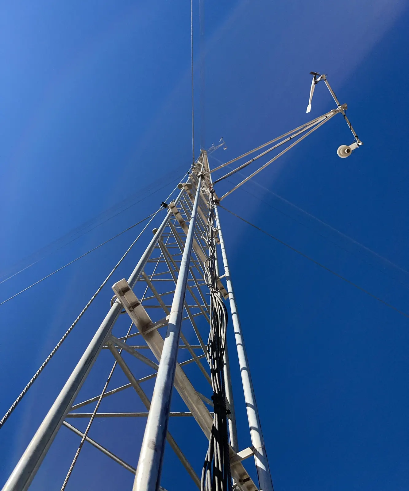 Looking up a guyed weather station tower with sensors