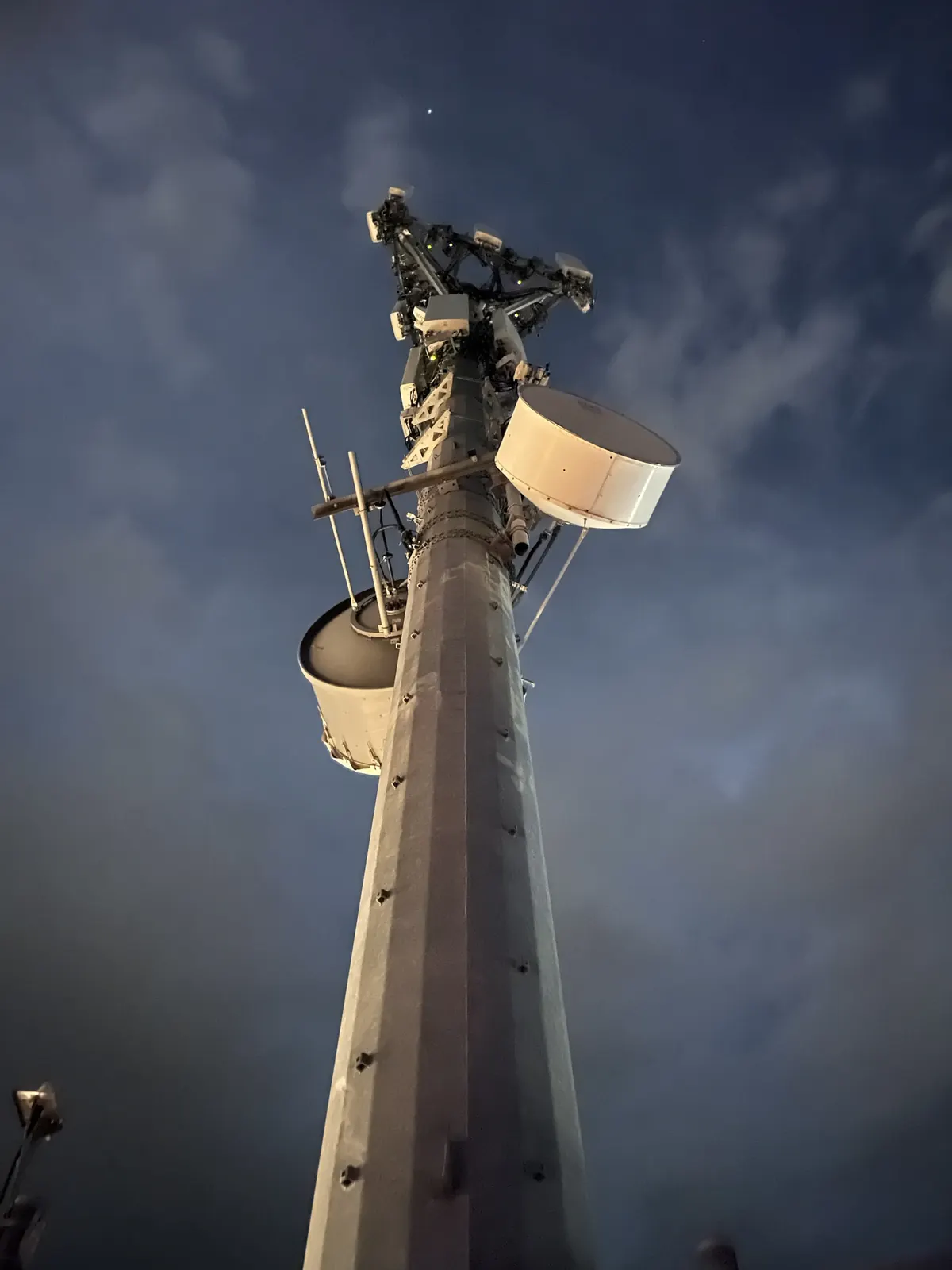 Monopole with microwave dishes and antennas at night